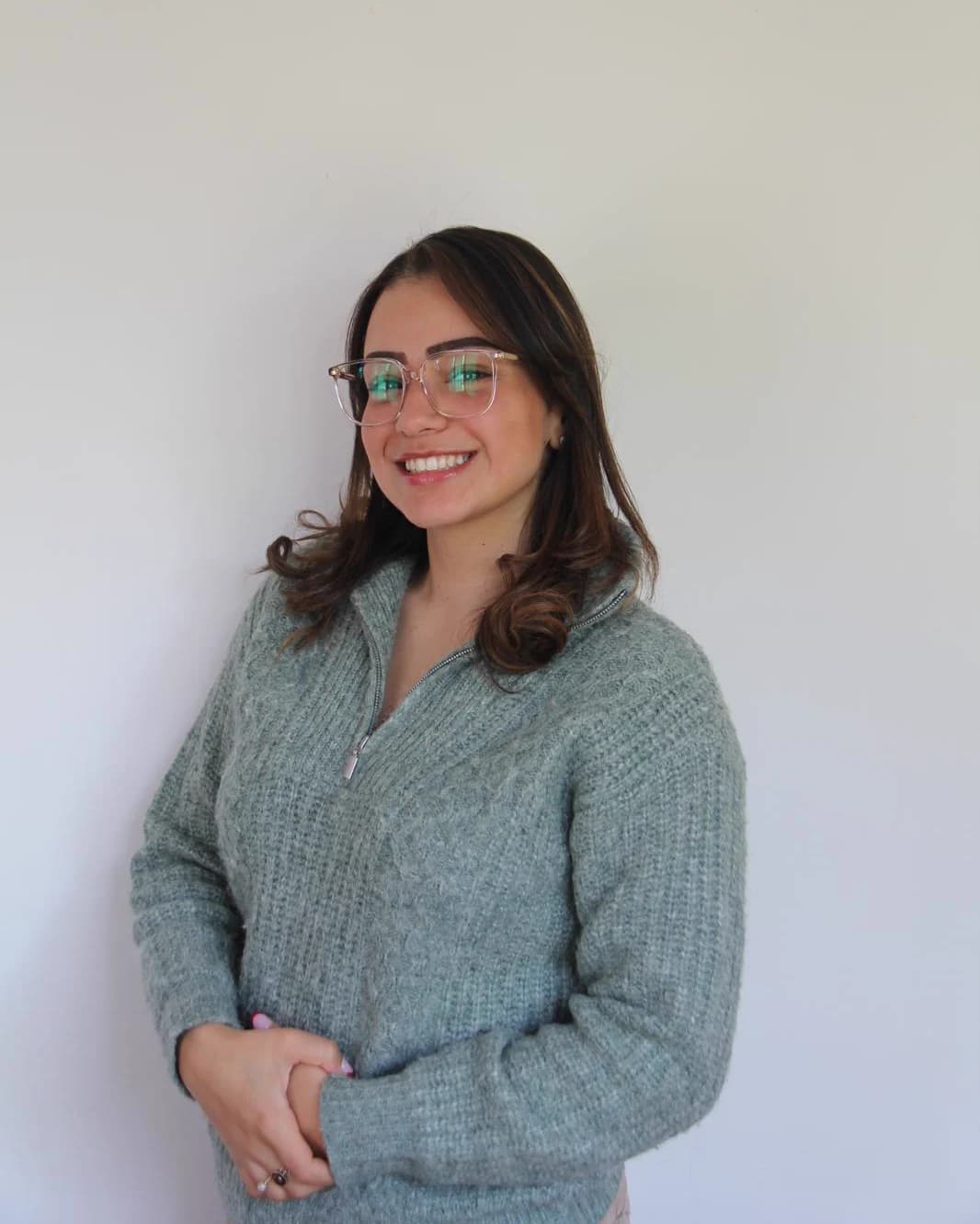 Portrait d’Inès, souriante, sur fond clair